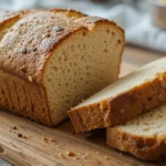 A freshly baked loaf of low carb sourdough bread with a crispy golden crust, sliced to reveal its airy texture.